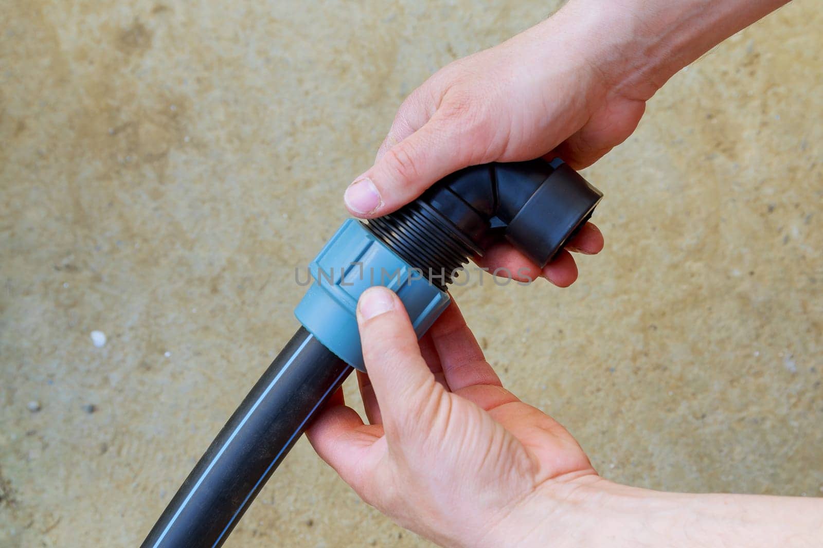 A plumber connects a polyethylene pipe using a special fitting for a polyethylene pipe.