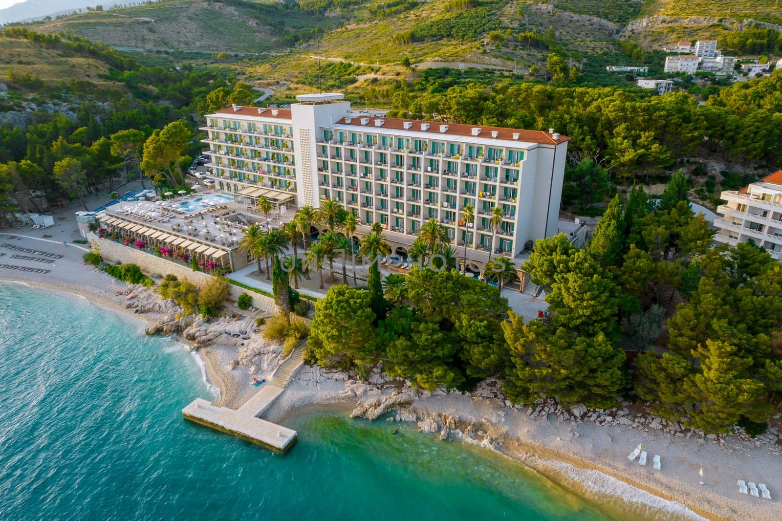 View from above. Hotel by the sea with landscaping. Sandy beach and pier. A beautiful holiday for tourists.