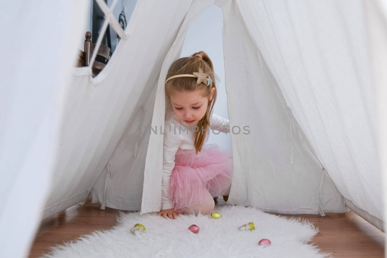 A girl searches eggs chocolate for Easter during self-isolation during the coronavirus pandemic