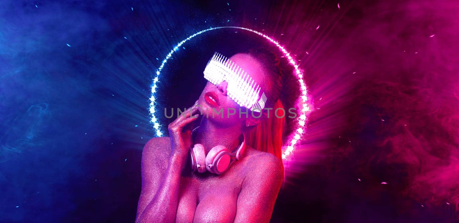 Girl DJ in neon lights with headphones. Beautyful woman and sexy TDJ at night club party
