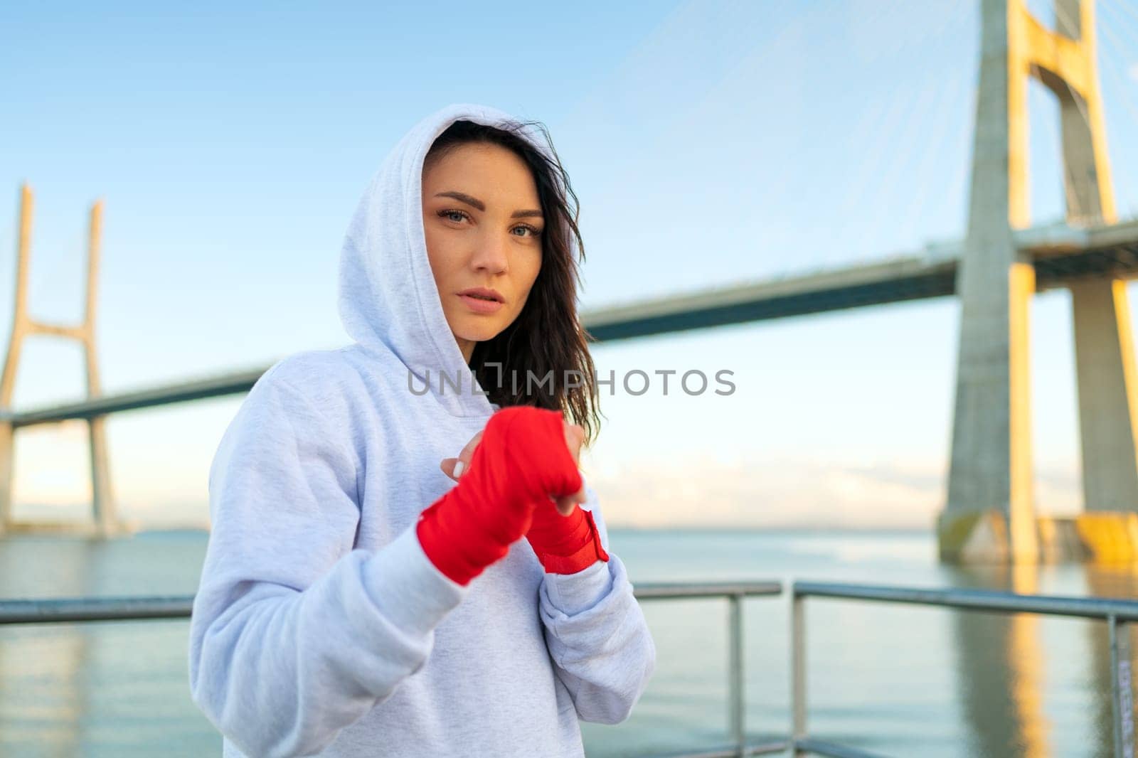 Female boxer in fighting stance staring into the frame, looking in camera powerful and confident women in boxing. Woman fighter, concept of strong woman and self defence.