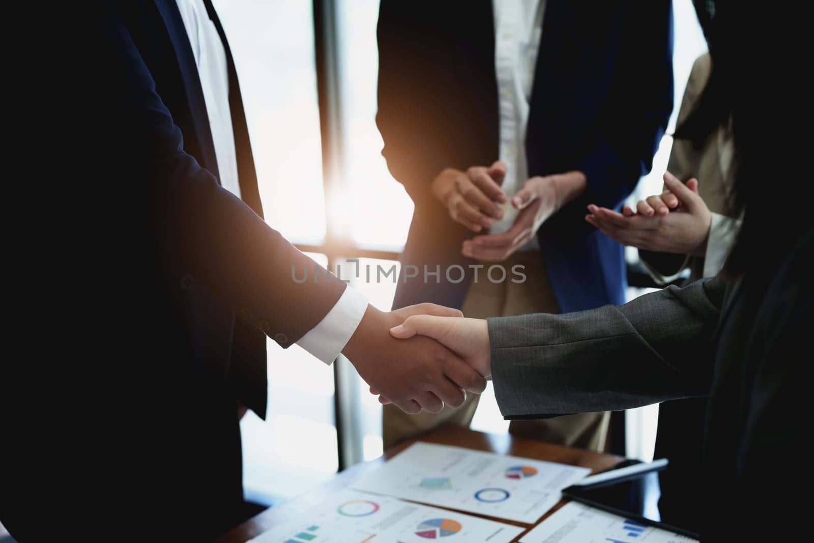 Asian entrepreneurs handshakes to congratulate the agreement between the two companies to enhance investment and financial strength. deal concept by Manastrong