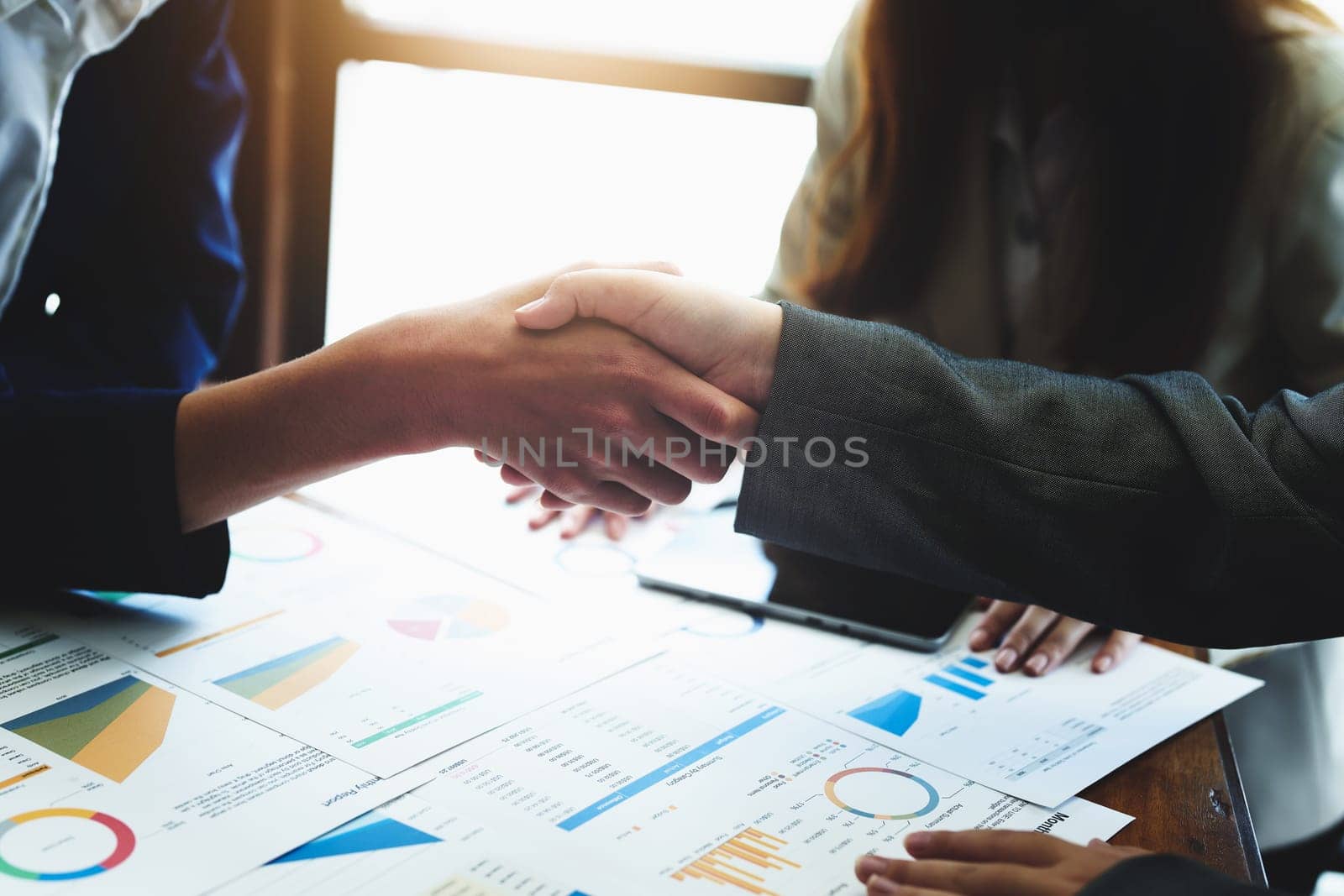 Asian entrepreneurs handshakes to congratulate the agreement between the two companies to enhance investment and financial strength. deal concept by Manastrong