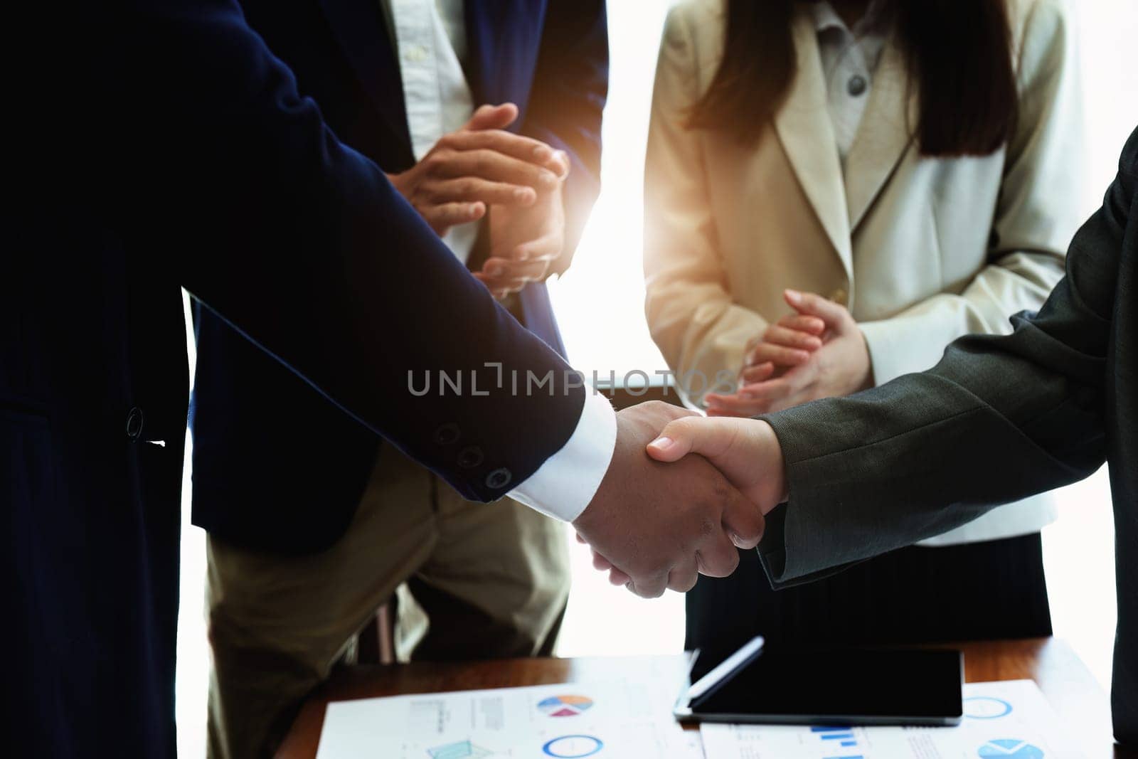 Asian entrepreneurs handshakes to congratulate the agreement between the two companies to enhance investment and financial strength. deal concept by Manastrong