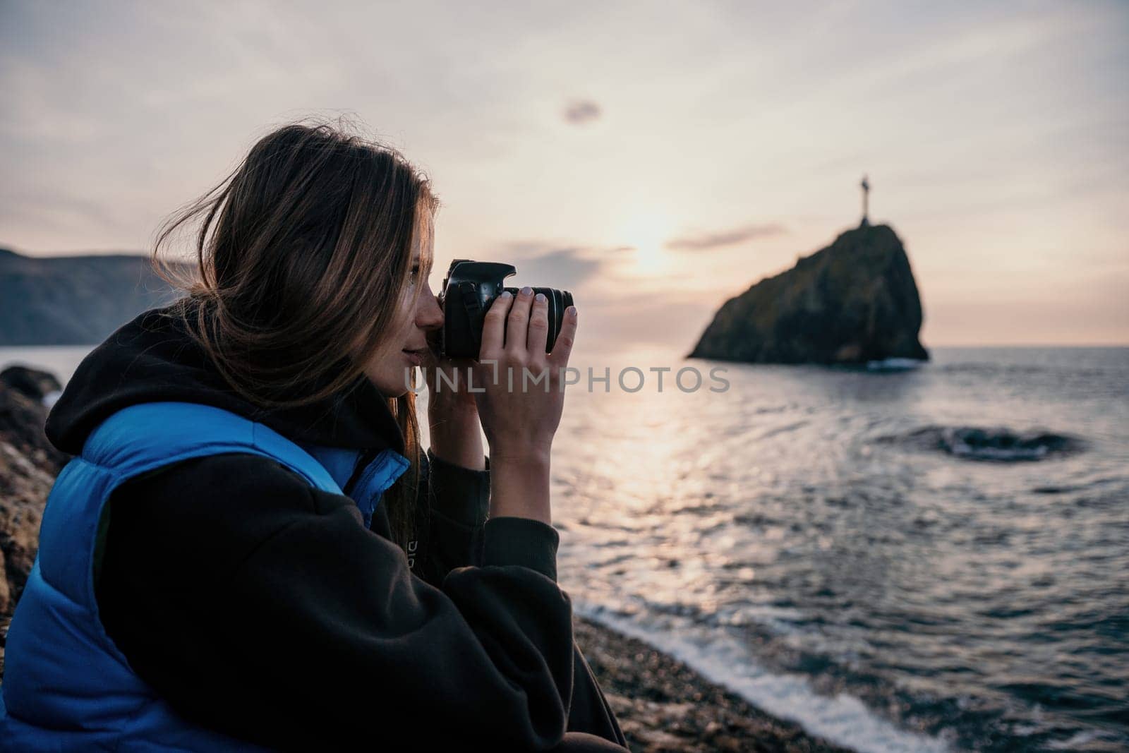 Woman travel sea. Happy tourist taking picture outdoors for memories. Woman traveler looks at the edge of the cliff on the sea bay of mountains, sharing travel adventure journey.