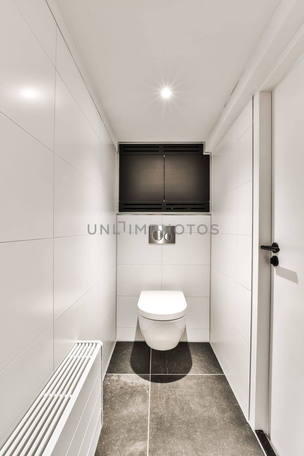 a white bathroom with a toilet and a television by casamedia