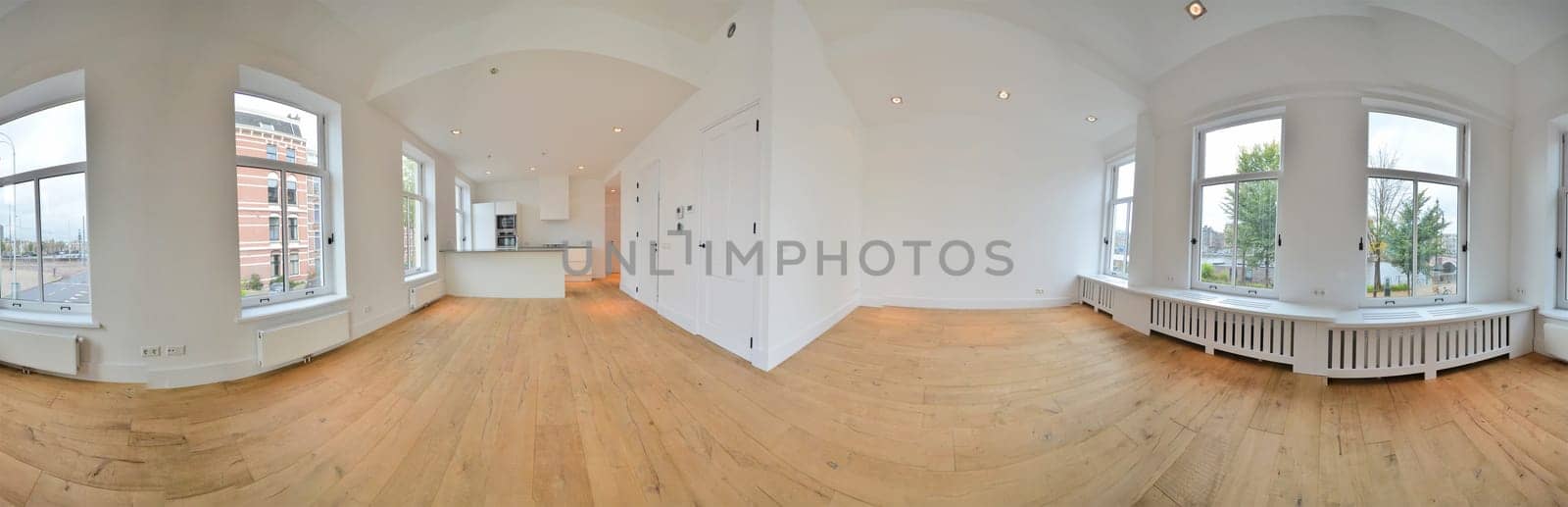 an empty living room with wood flooring and large windows looking out onto the street in front of the house