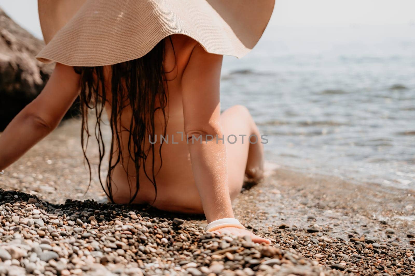 Woman travel sea. Happy tourist in hat enjoy taking picture outdoors for memories. Woman traveler posing on the beach at sea surrounded by volcanic mountains, sharing travel adventure journey by panophotograph