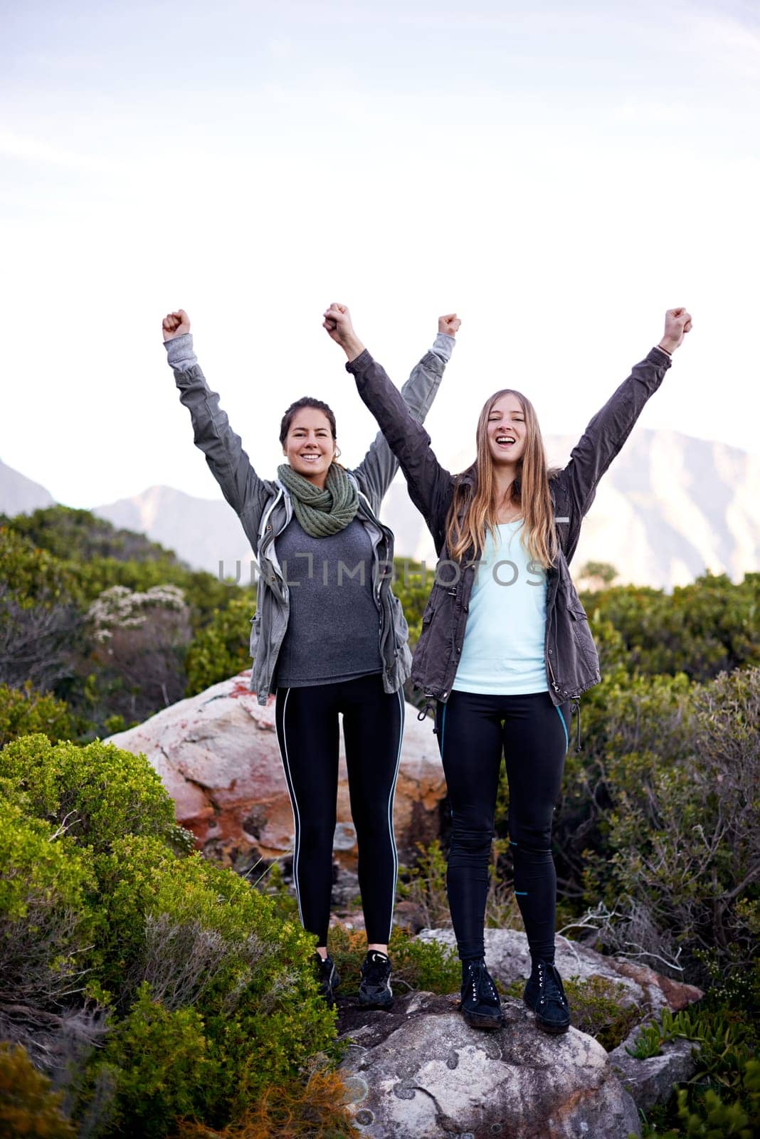 We made it. Portrait of two excited young female hikers in the outdoors. by YuriArcurs