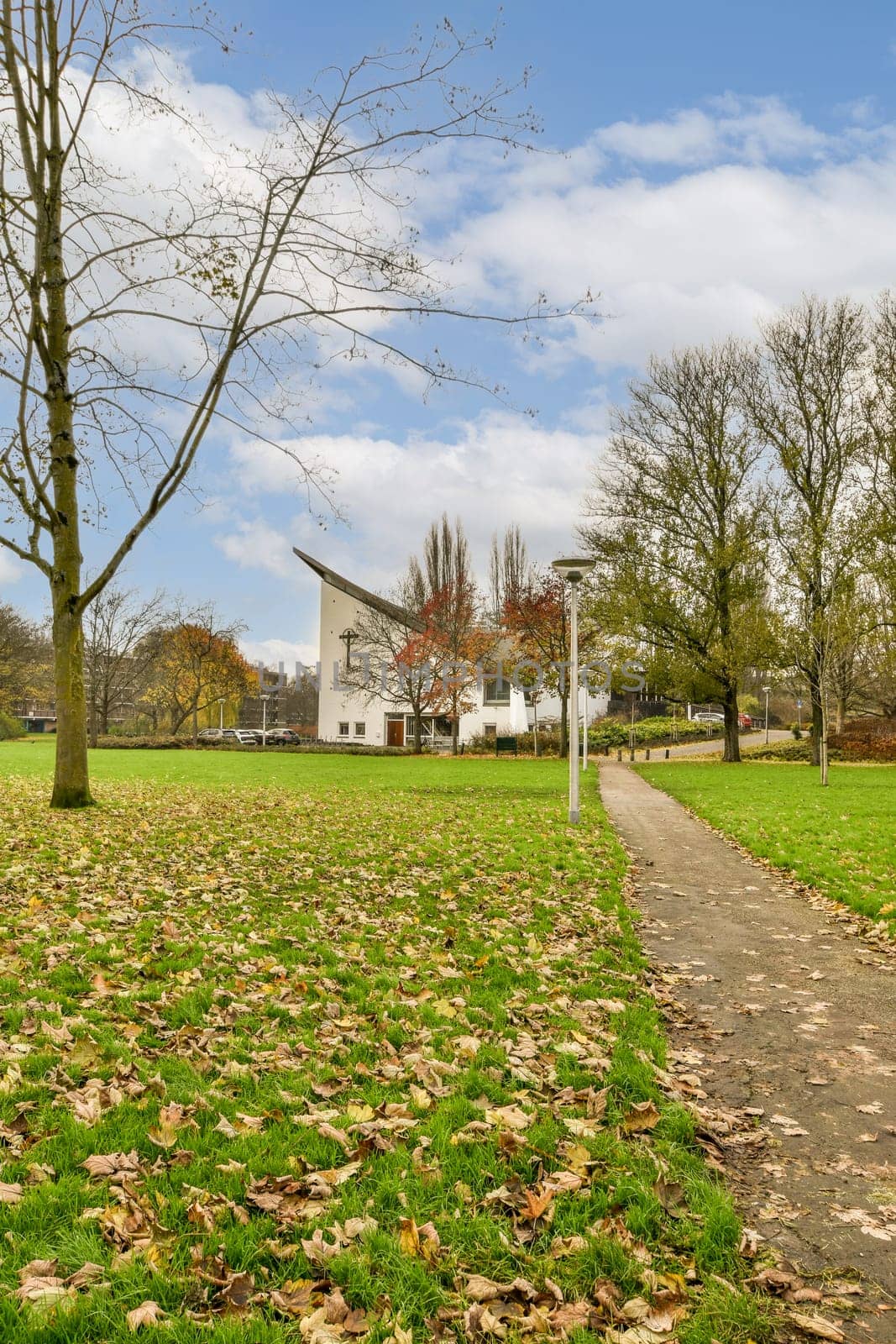 a path leading to a white house in a park by casamedia