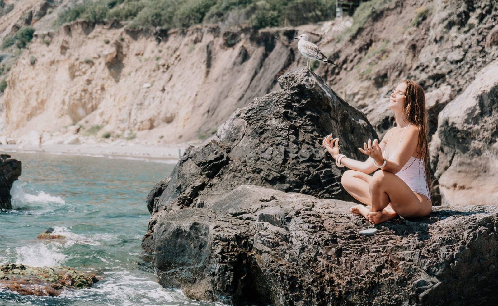 Woman travel sea. Happy tourist in white bikini enjoy taking picture outdoors for memories. Woman traveler posing on the beach at sea surrounded by volcanic mountains, sharing travel adventure journey by panophotograph