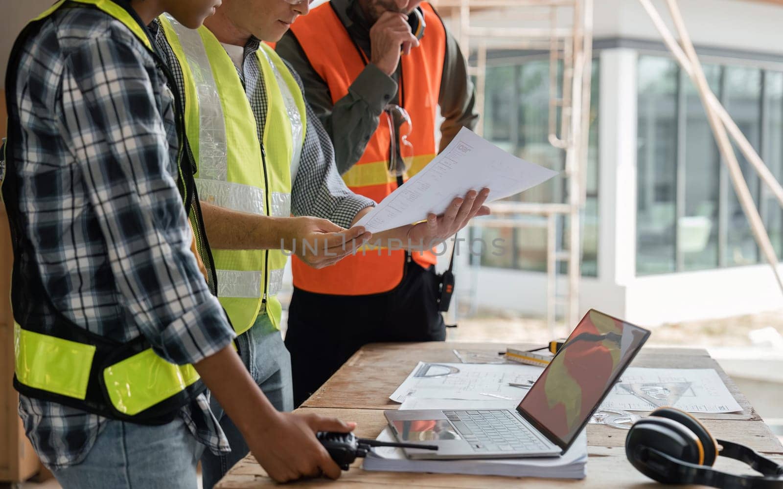 engineer team planning and discussing about construction building on table in working site.