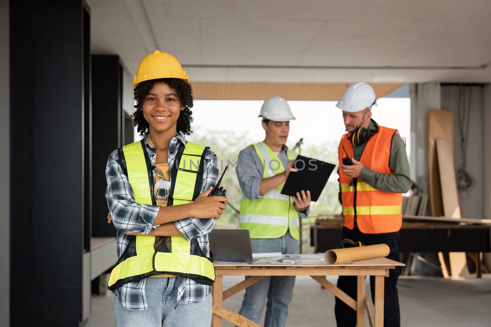 Portrait of female engineer holding walkie talkie and male engineer with working together inspection housing estate project at the construction site.