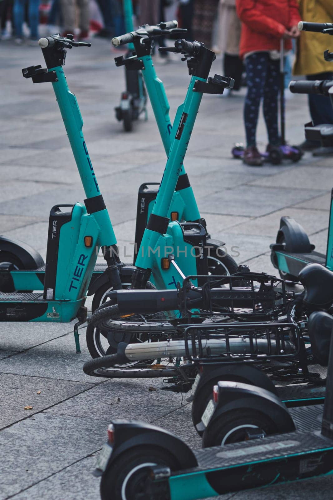 Vertical shot of a pile of e-scooters and e-bikes