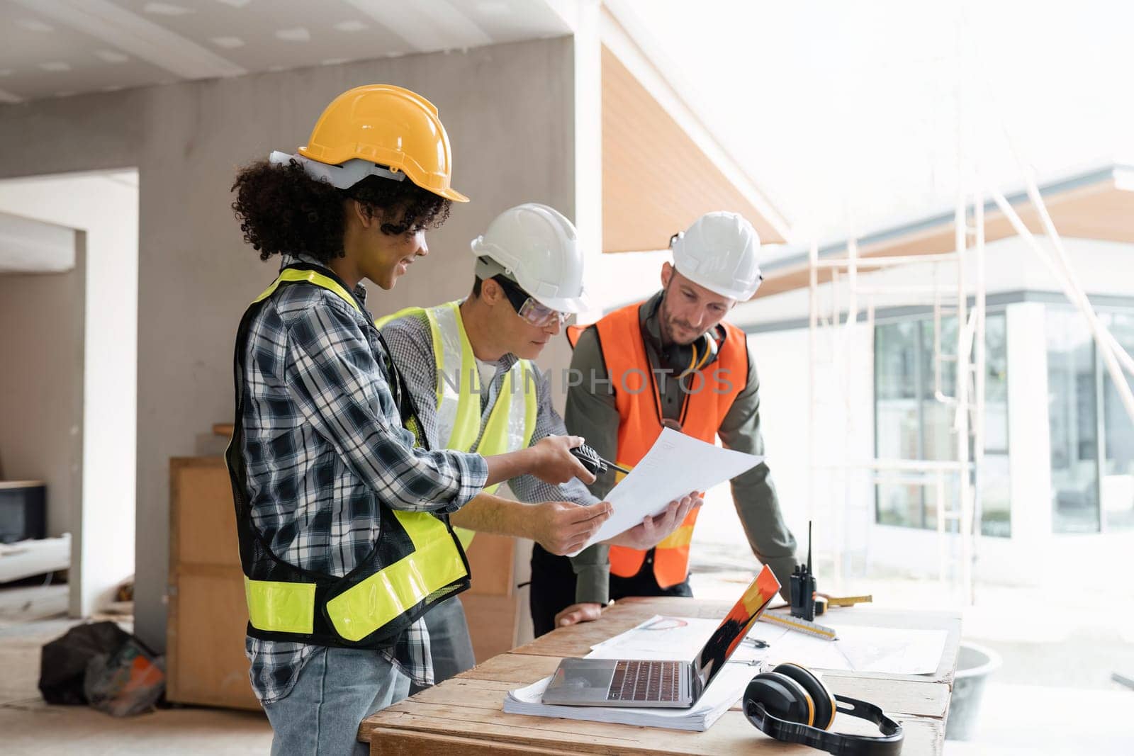 engineer team planning and discussing about construction building on table in working site.