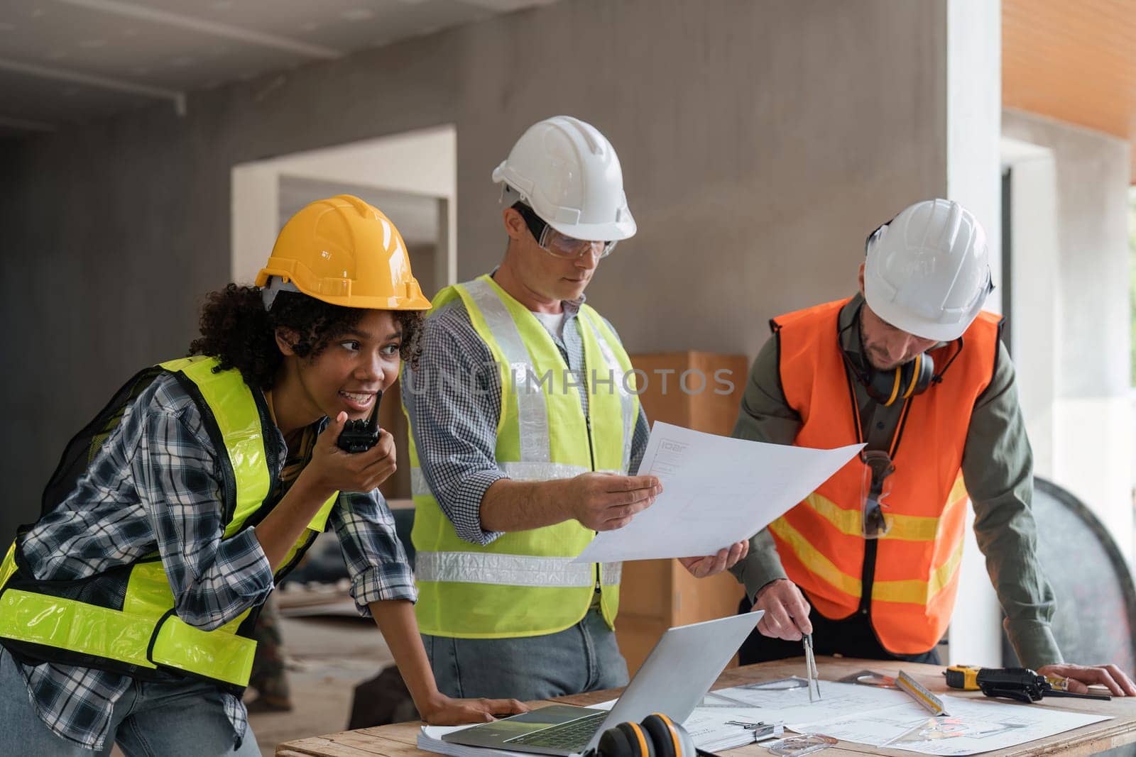 female architect holding walkie talkie and male civil engineer with working together inspection housing estate project at the construction site.
