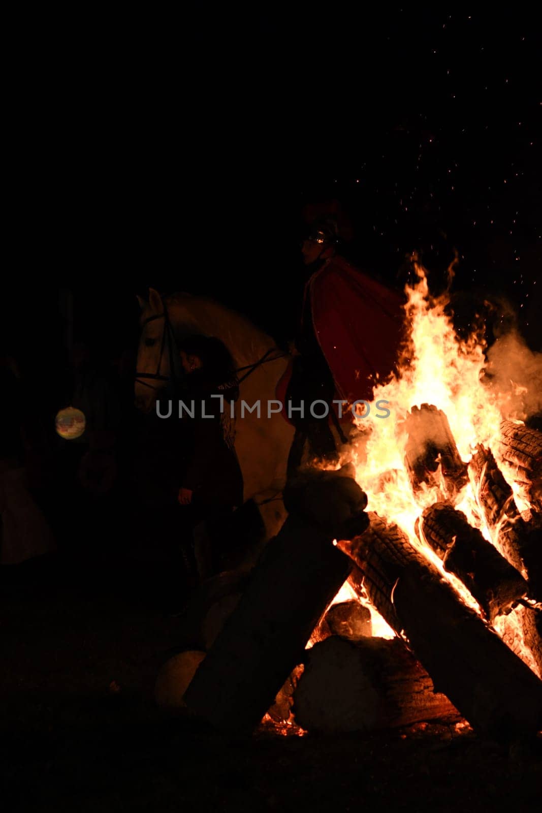 Large blazing bonfire at night with St. Martin on horseback in background in Huenxe, Germany