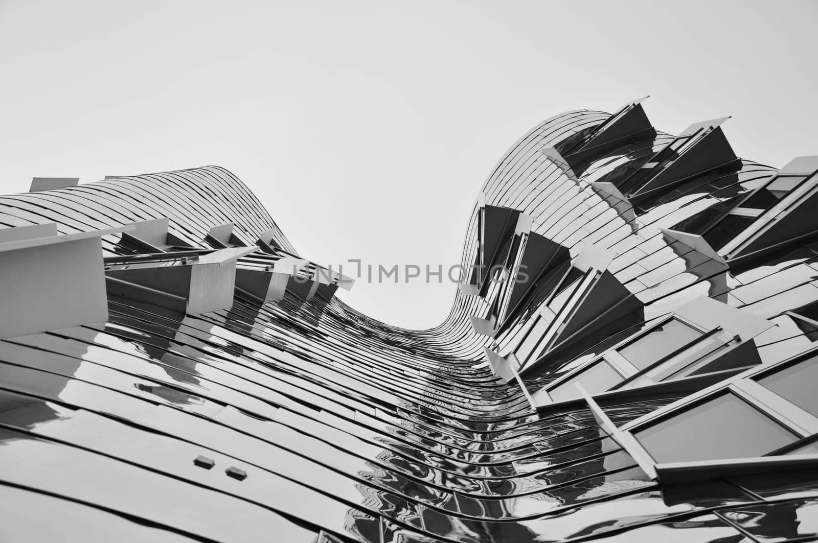 Monochrome, low-angle shot of the mirrored facade of the Gehry building in Dusseldorf, Germany
