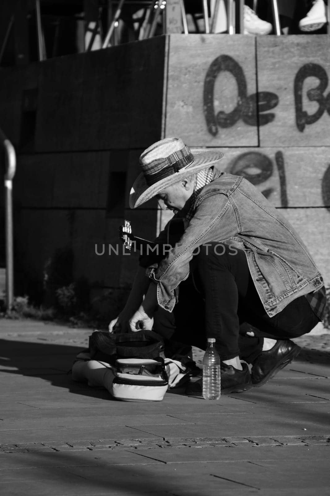 Street musician in a hat unpacking his guitar in Duesseldorf, Germany