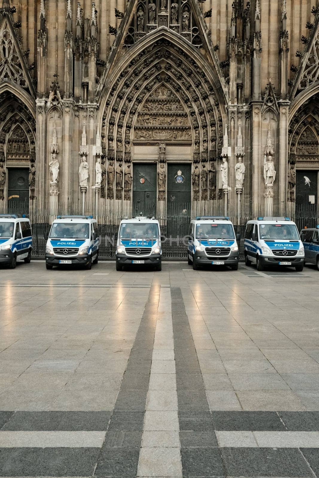 Row of Mercedes-Benz Sprinter police cars in front of Cologne Cathedral in Germany