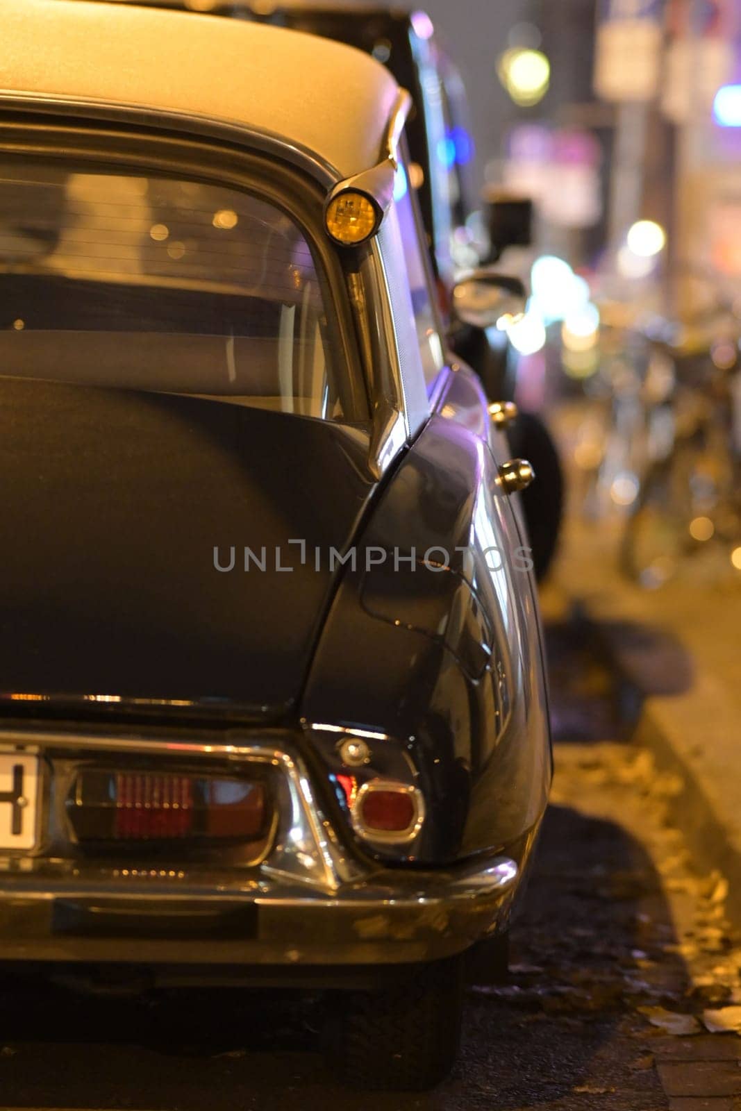 Black french classic car parked in front of other cars at night in Duesseldorf, Germany