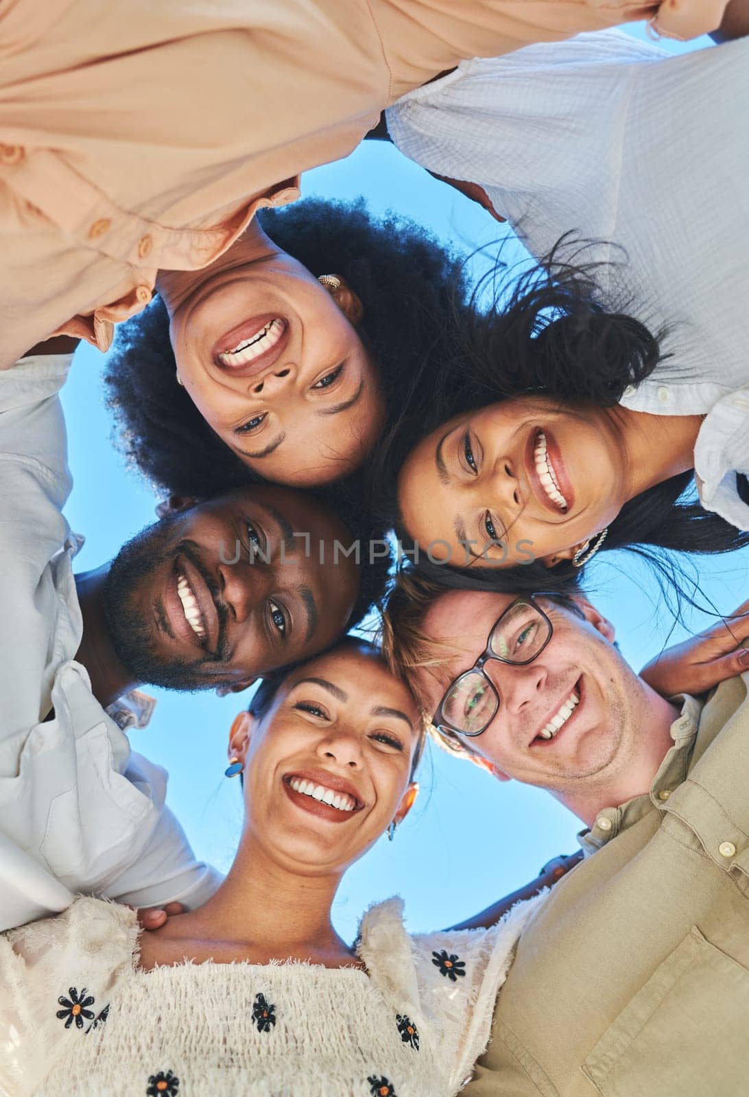 Trust, happy and friends portrait huddle for bonding, hug and summer fun together with smile. Adventure, freedom and happiness of excited young people in interracial friendship with low angle. by YuriArcurs