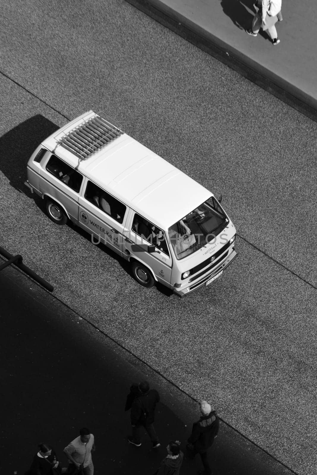 Vertical black and white shot of a Volkswagen Bulli on an empty road