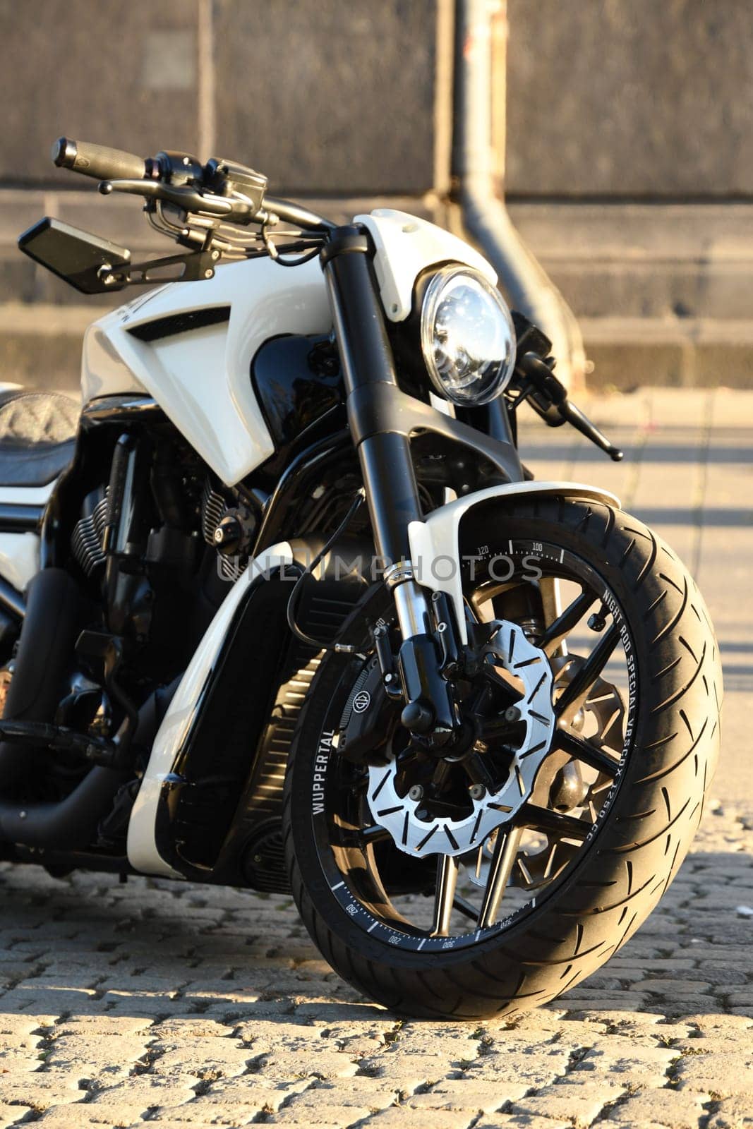 Vertical closeup of a white chopper motorcycle parked under the sunlight. Harley Davidon in Duesseldorf, Germany.