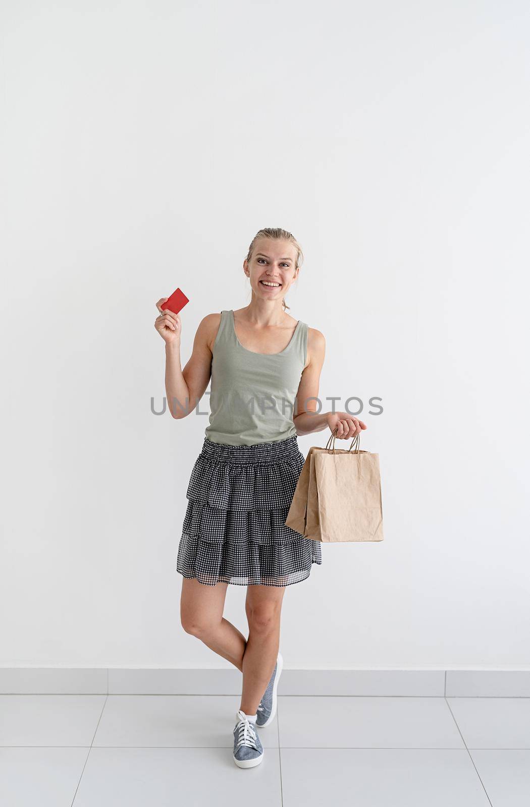 Online shopping concept. Young smiling woman holding eco friendly shopping bags and creadit card. Mock up