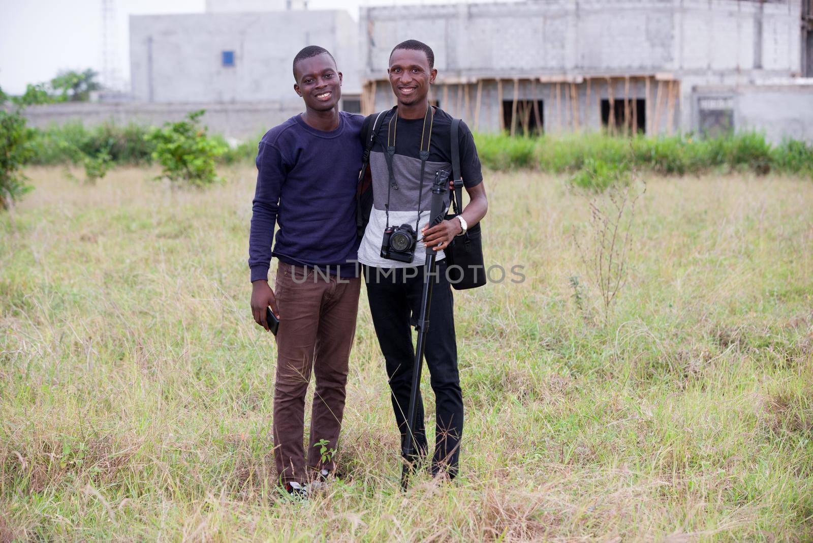 two happy young tourists with their camera and a backpack after an outdoor trek