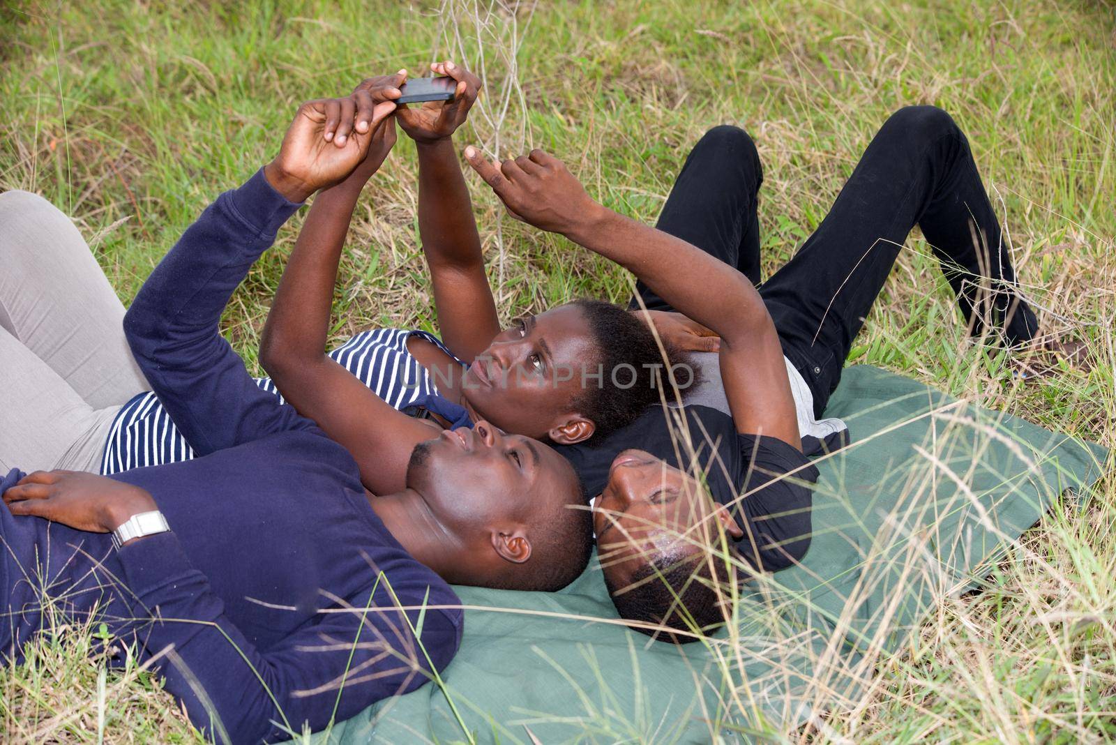 best friends man and woman lying on the grass and laughing by vystek