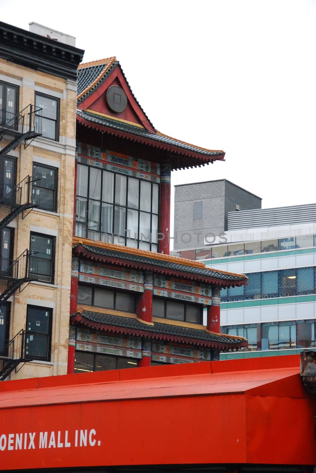 Vertical shot of a Chinese temple next to New York townhouses