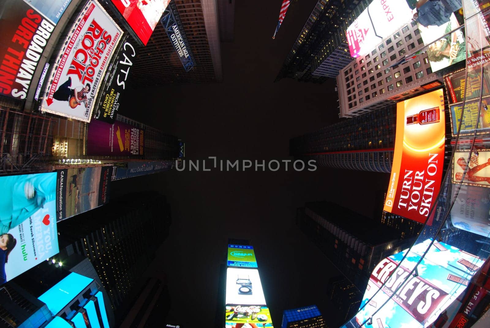 Low angle shot of billboards and neon signs on skyscrapers in the Times Square in New York at night