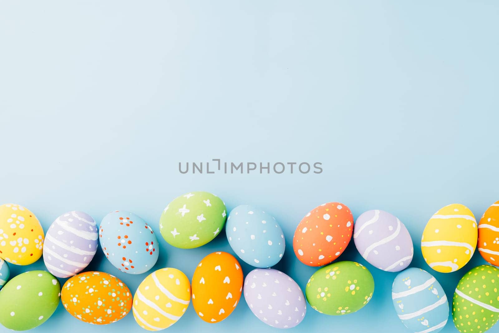 Overhead easter eggs isolated on blue background with copy space, Funny decoration, Happy Easter Day greeting card, Creative composition banner web design holiday background, flat lay top view