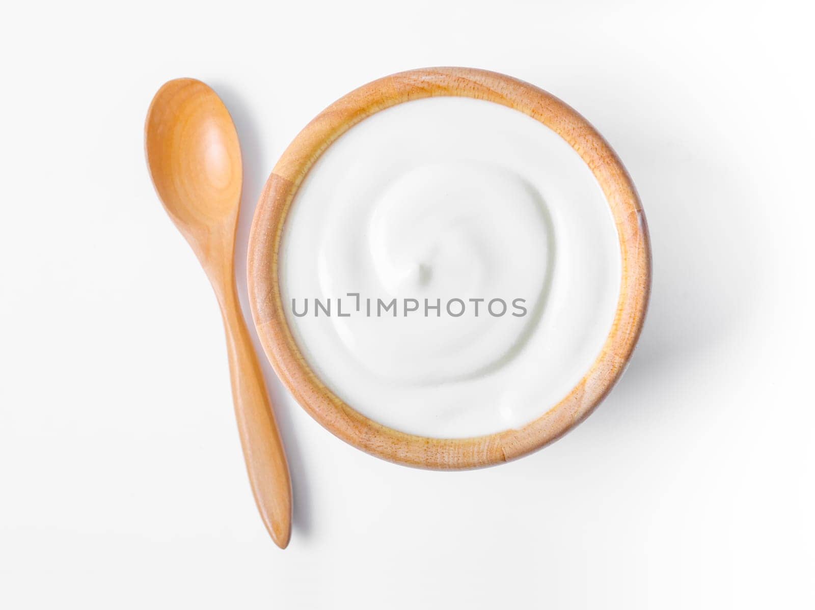 The Fresh greek yogurt in wooden bowl with wooden spoon on white background. Healthy breakfast. by Gamjai