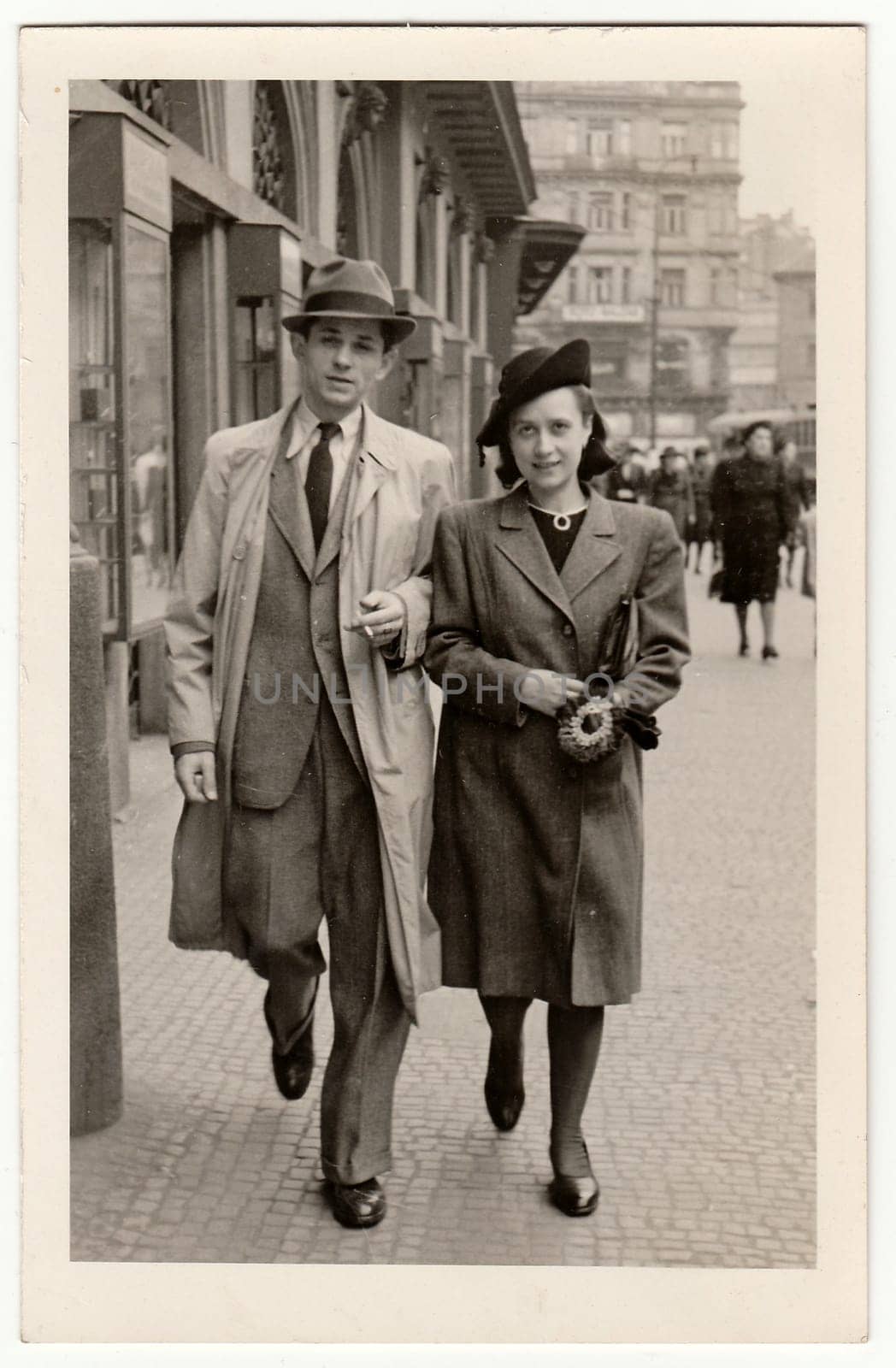 Vintage photo shows a young couple walks along the street. by roman_nerud