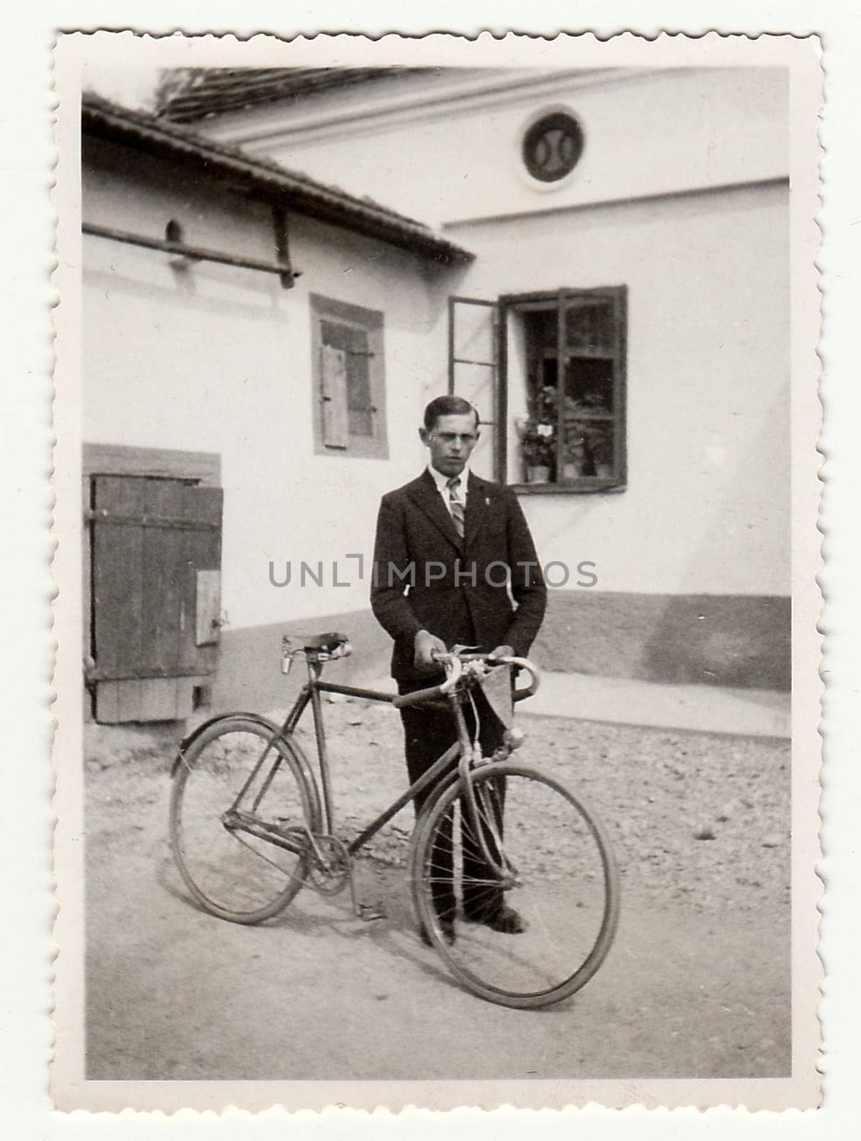 Vintage photo of a young man with bicyckle on the back yard. by roman_nerud