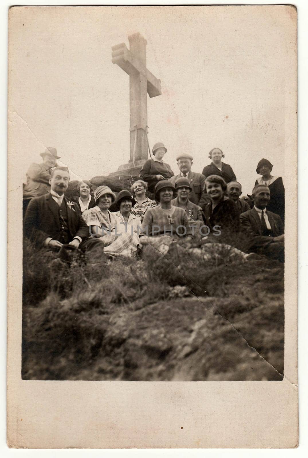 Vintage photo shows people on trip. People sit at the Christian cross. by roman_nerud