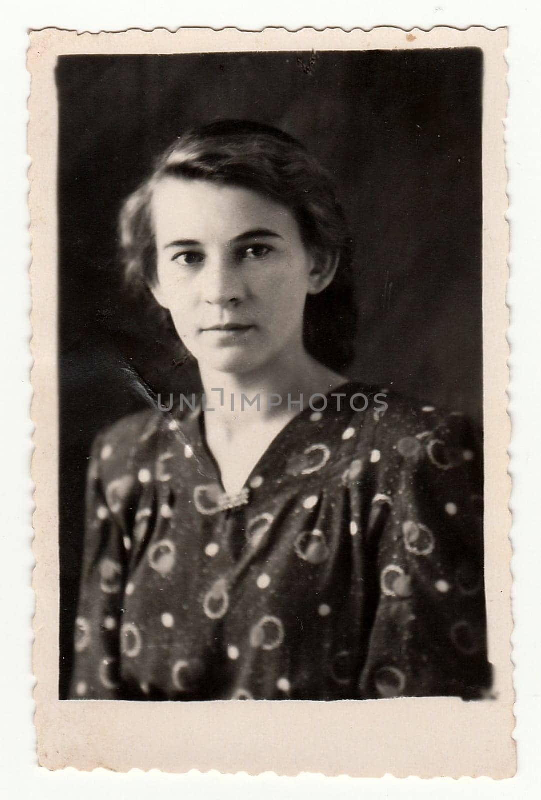 Vintage portrait shows a young woman. Black & white antique photo. by roman_nerud
