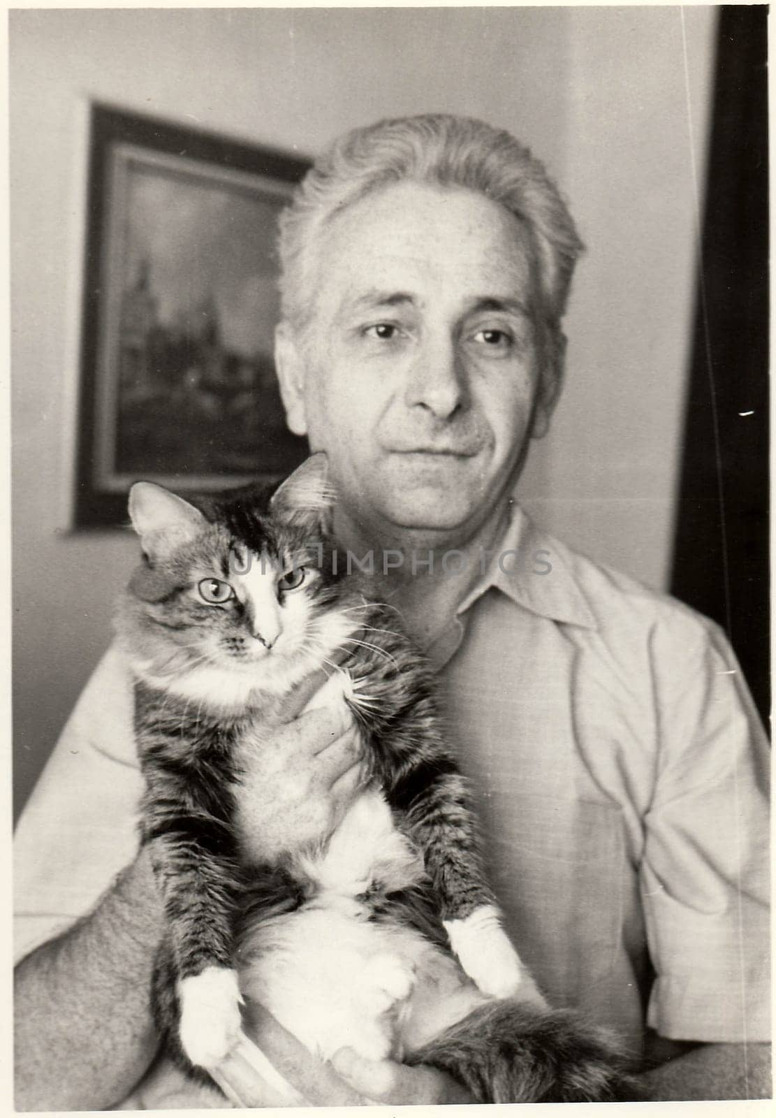 Vintage photo shows man cradles cat. by roman_nerud