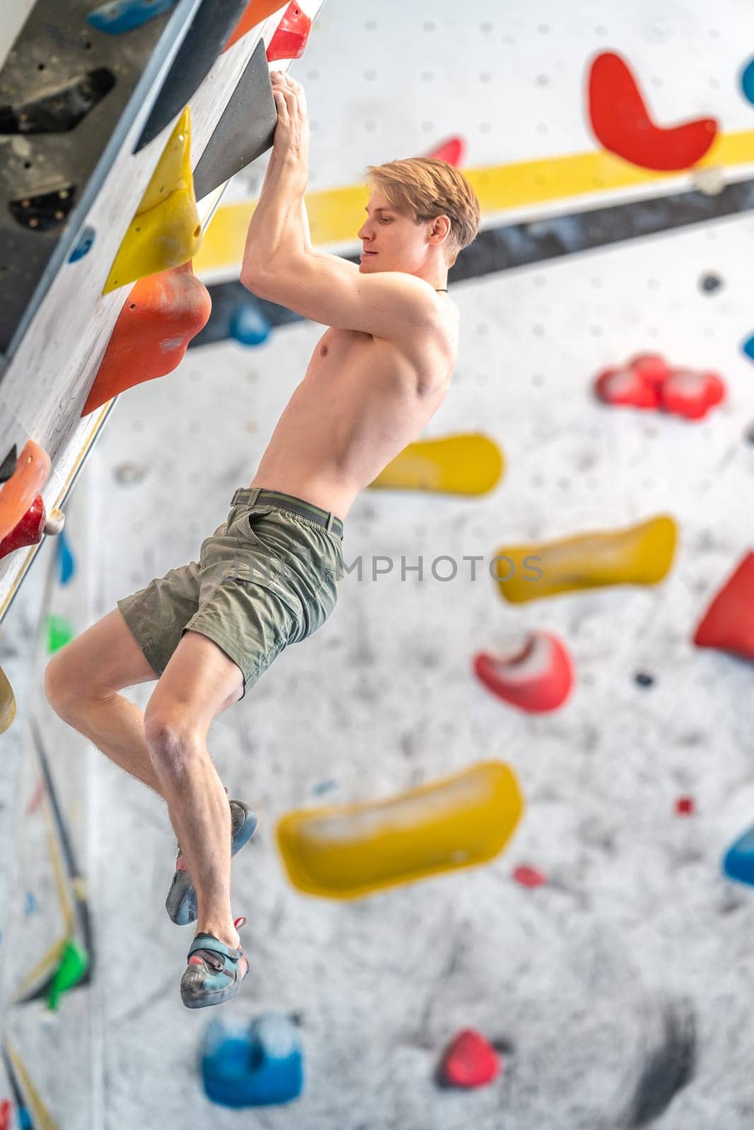 young man on a boulder climbing wall. High quality photo
