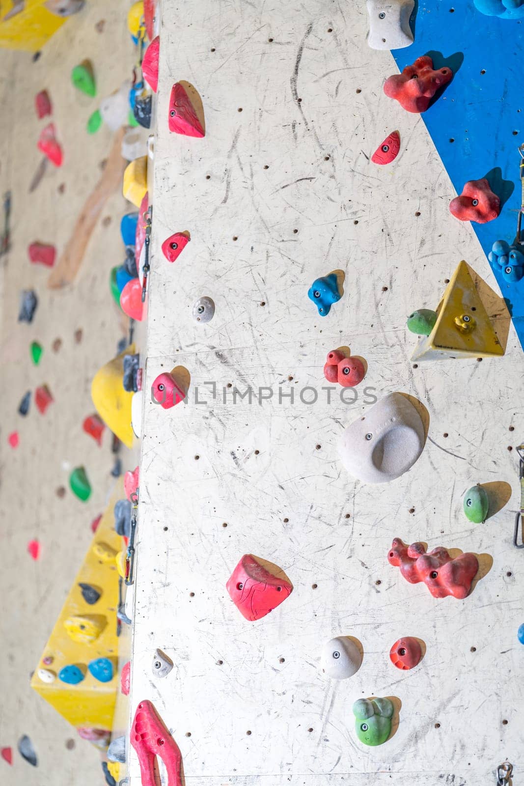 artificial climbing wall with grips and carabiners in the interior. High quality photo