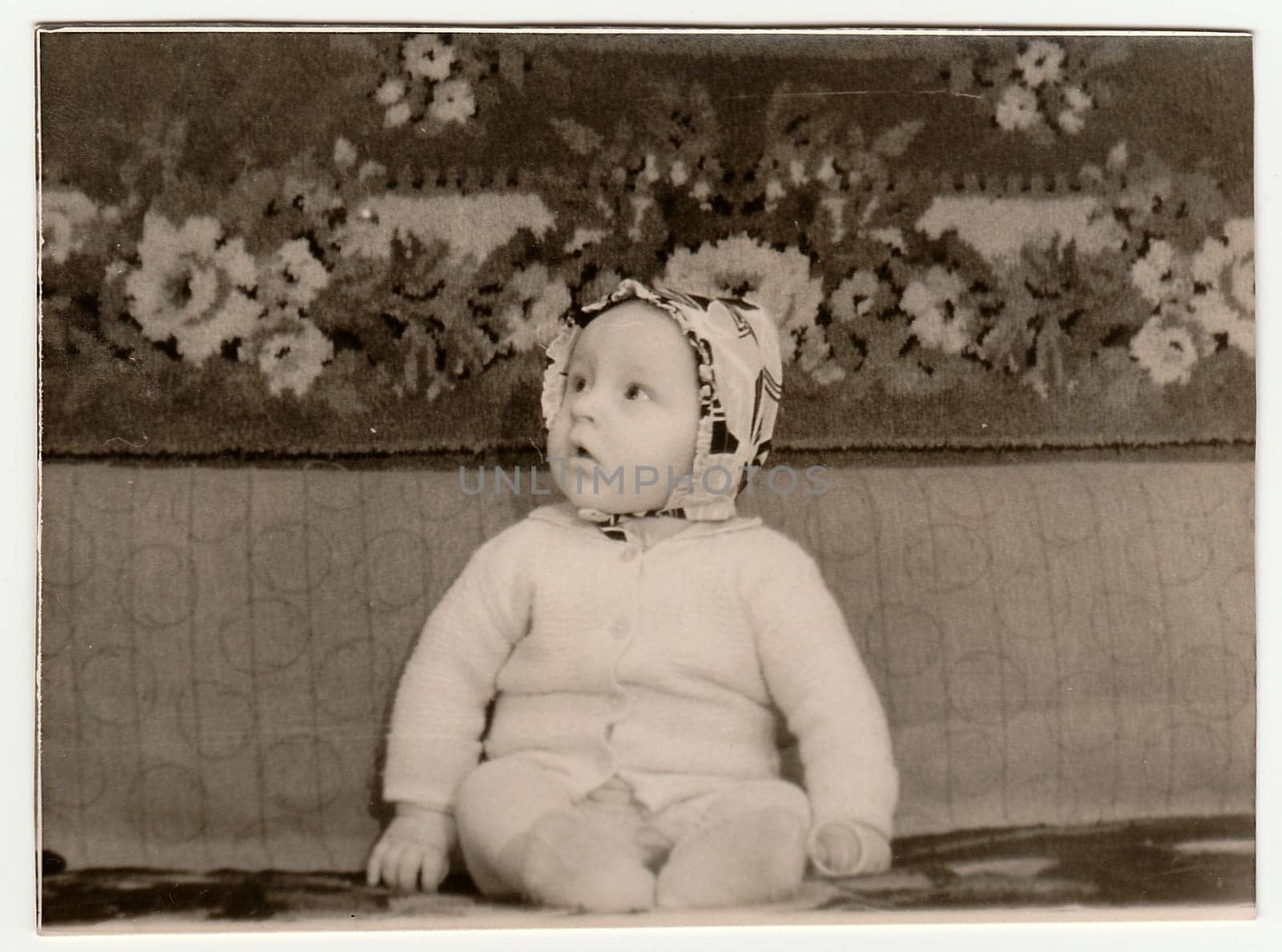 Vintage portrait shows toddler sits on sofa. Black & white antique photo. by roman_nerud