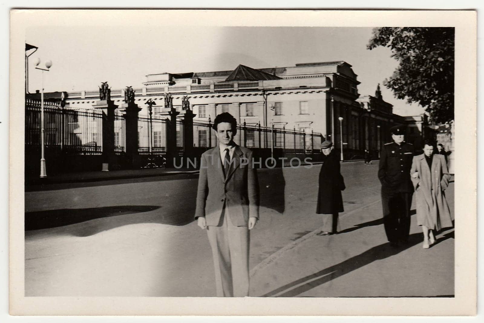 Vintage photo shows a young man poses on the street. Black & white retro photo. by roman_nerud