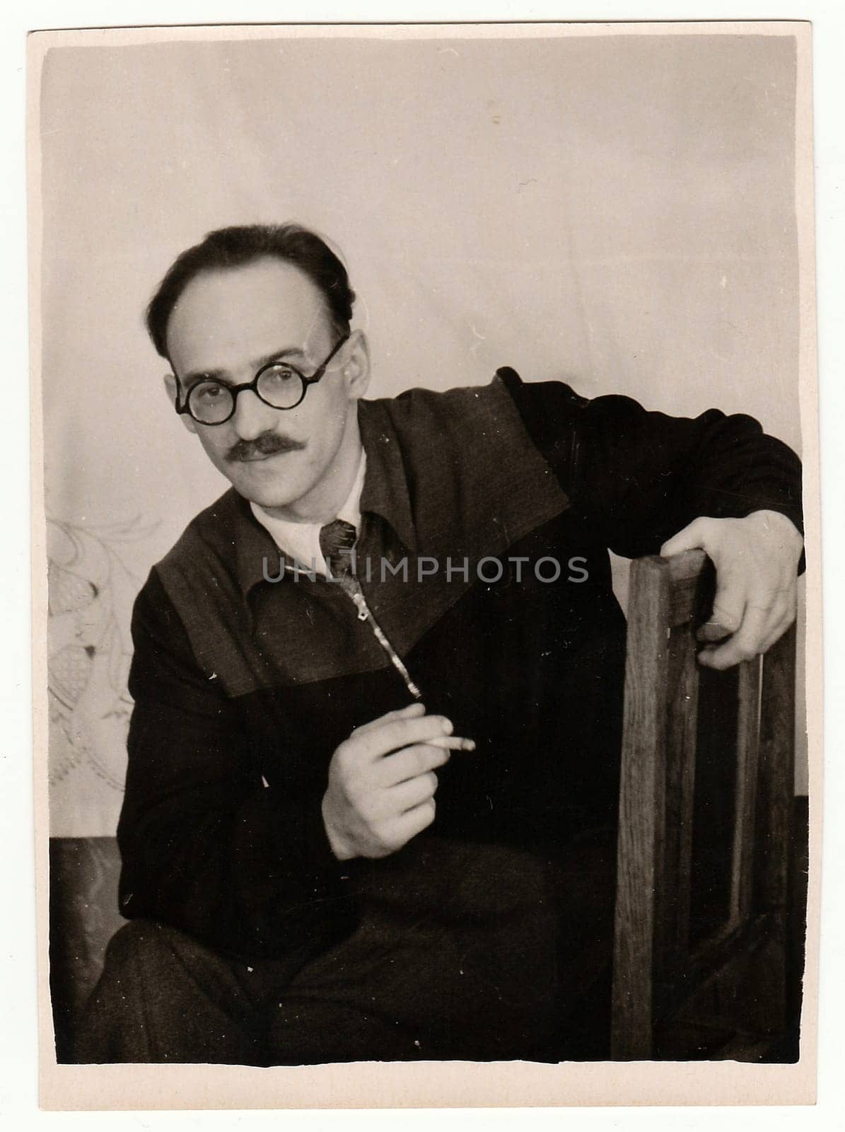 USSR - CIRCA 1960s: Vintage portrait of a young man with glasses and moustache smokes cigarette.