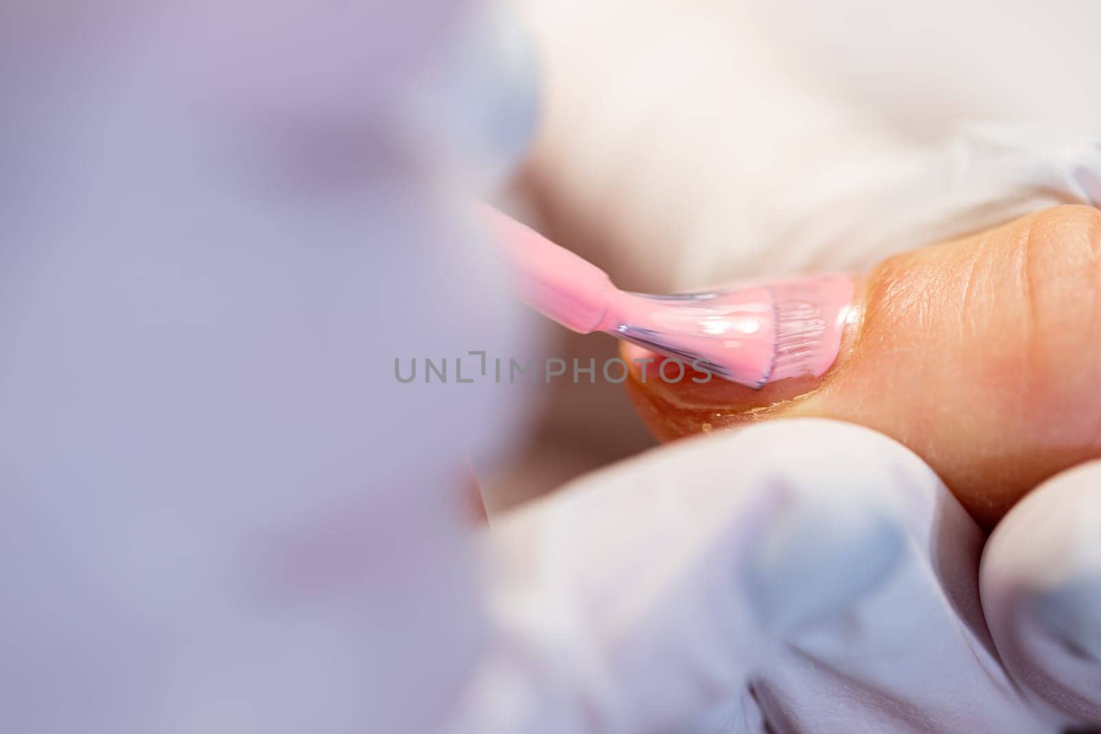 Preparation of the nail plate for further cosmetic procedures. Maintaining the principles of hygiene in the beauty salon. Working as a beautician and manicurist. Close-up on the hands of a beauty salon client.