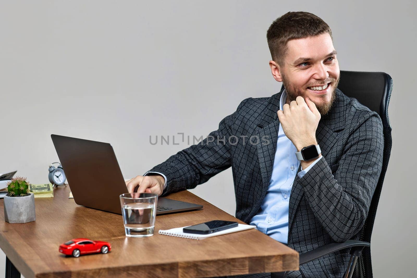 young happy bearded man sitting at desk work on laptop pc computer