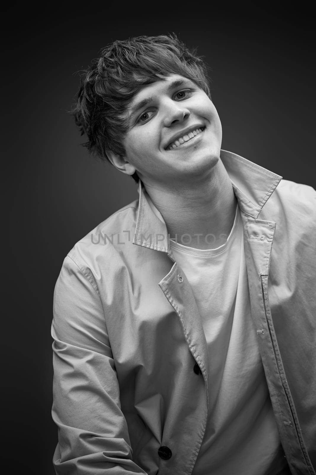 portrait of caucasian man with hairstyle in coat on black background. fashion modern style look. black and white