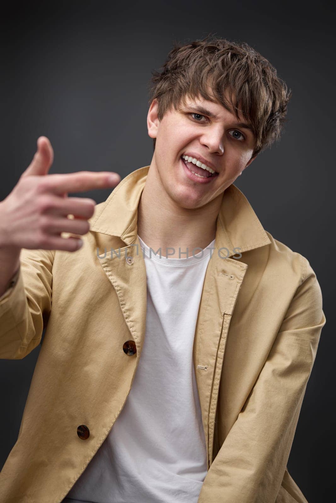 cool caucasian man with hairstyle in coat on black background. fashion modern style look