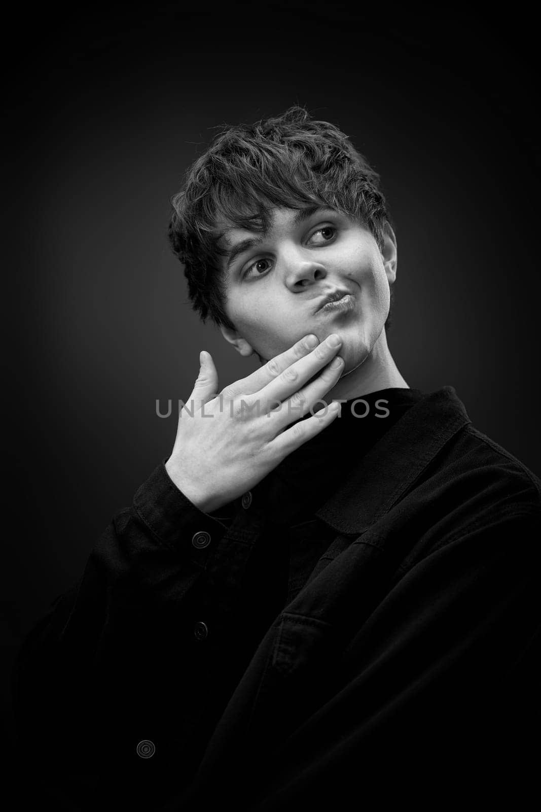 portrait of handsome man touching chin with hand and looking at the side. black and white.